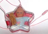 Glitzer- Sterndose mit Babypuppe und Mini-Teddy - zum Schließen ins Bild klicken